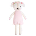 A dog plushie wearing a pink dress and a flower crown 