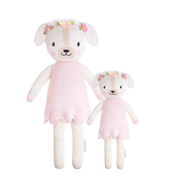 2 different sized dog plushies wearing pink dresses and a flower crown standing side by side